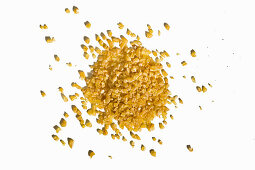 A heap of kamut bulgur on a white surface