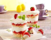 Strawberry and yoghurt layer cake in jars decorated with white chocolate strawberries
