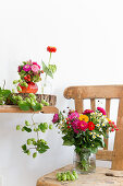 Late summer bouquets and hop vines on wooden table and chair