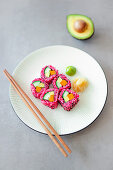 Vegan sushi with beetroot rice, avocado, carrots and cucumbers