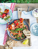 Tomato salad with rocket and grilled vegetable skewers with peppers, red onions, feta cheese and cherry tomatoes