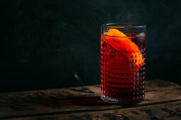 Negroni cocktail (old fashioned) with gin, vermouth and campari, decorated with an orange twist