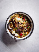 Baharat lamb shoulder with pearl onions and mogbrabich
