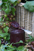 Gooseberry and redcurrant jam in a glass with a spoon