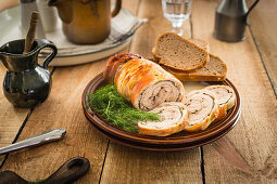 Kalbsrollbraten, angeschnitten, mit Dill und Brot