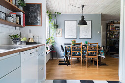 Offene Küche, im Hintergrund Essbereich mit grauer Wand und Parkettboden