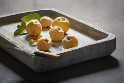 Quinces in a flat wooden dish