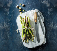 Grüner Spargel mit Messer auf Schneidebrett