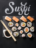 Sushi served on blackboard with the word Sushi handwritten with chalk