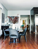 Dining area with black classic chairs, black tiled wall in the background
