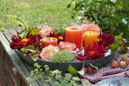 Dahlien und Rosenblüten mit Kerzen in Schale mit Wasser