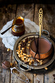 Hot chocolate with peanut caramel in a copper pan