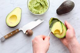 An avocado being scooped out