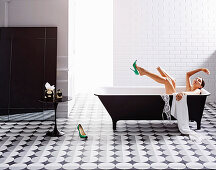 Black and white bathroom with cement tiles, woman in the bathtub