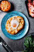 Breakfast pizza with egg, beacon and beans