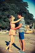 Junges Paar hält sich verliebt in den Armen am Strand