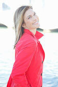 A blonde woman wearing a red trench coat