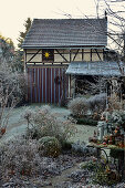 Winterlicher Garten mit Scheune im Hintergrund