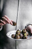 Raw vegan date almond truffles being help by a woman