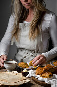 A woman eating pumpkin scones with coffee