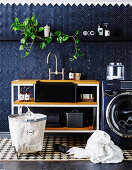 Waschtisch neben Waschmaschine im Waschraum mit blauen Wandfliesen