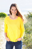 Brünette Frau in gelbem Pullover und Jeans