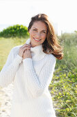 Brunette woman wearing white knit sweater