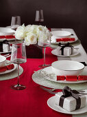 Table set for Christmas dinner witha red white and black theme