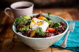 A rice bowl with poached eggs and bacon