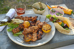 Grilled tandoori chicken skewers with a beetroot dip and lemons