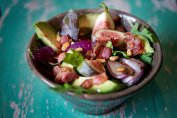 Fig salad with bacon, avocado, red onions and pine nuts