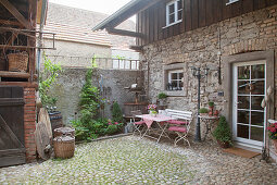 Table, chairs and bench on stone terrace