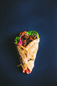 Veganer Shawarma mit Pulled Jackfruit auf blauem Untergrund