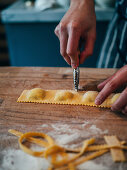 Crop person cutting ravioli