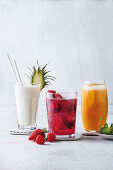 Kokosmoothie mit Ananas und Banane, rote Beeren-Sangria und Mango-Orangenfizz mit Ingwer