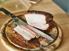Grilled pork belly being sliced