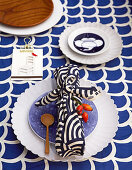 Gift wrapped in patterned blue fabric on plate