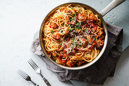 Spaghetti mit Fleischbällchen, Tomatensauce, Petersilie und Käse