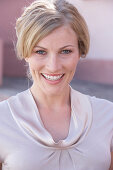 A blonde woman wearing a light blouse