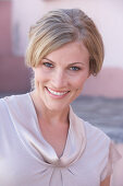 A blonde woman wearing a light blouse