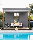 Dog lies in front of the covered terrace by the pool