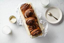 Swirl bread loaf in baking pan on white concrete background