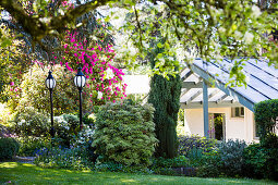 Sommerlicher Garten mit Laternen, Blick auf Haus