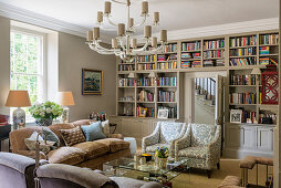 Murano chandelier and sofas and chairs in living room with inbuilt book shelves