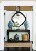Console table with Asian vases against a cassette wall