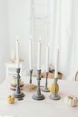 Herbstliche Tischdeko mit Kerzenleuchtern, Kürbissen und Baumscheiben