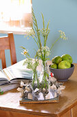 Wildflowers in bottles surrounded by DIY wreath made from strips of fabric