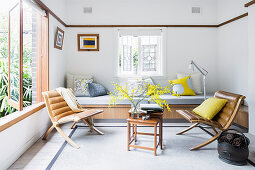 Vintage leather chairs and side table in front of built-in bench in living room