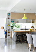 Bright, open kitchen with counter and polished concrete floor, in the back and toddler