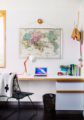 Weißer Schreibtisch darüber Weltkarte im Home Office